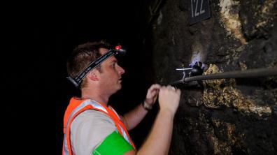  L’expert de l’IRSN pose un détecteur solide  de trace nucléaire (DSTN),  pour la mesure volumique   en radon dans un tunnel de la SNCF